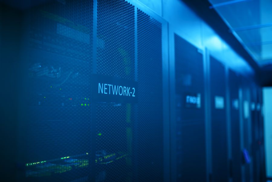 A modern server room with racks of network equipment lit in blue