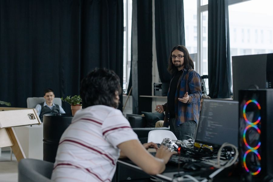 Young professionals collaborating around laptops in a modern software company office