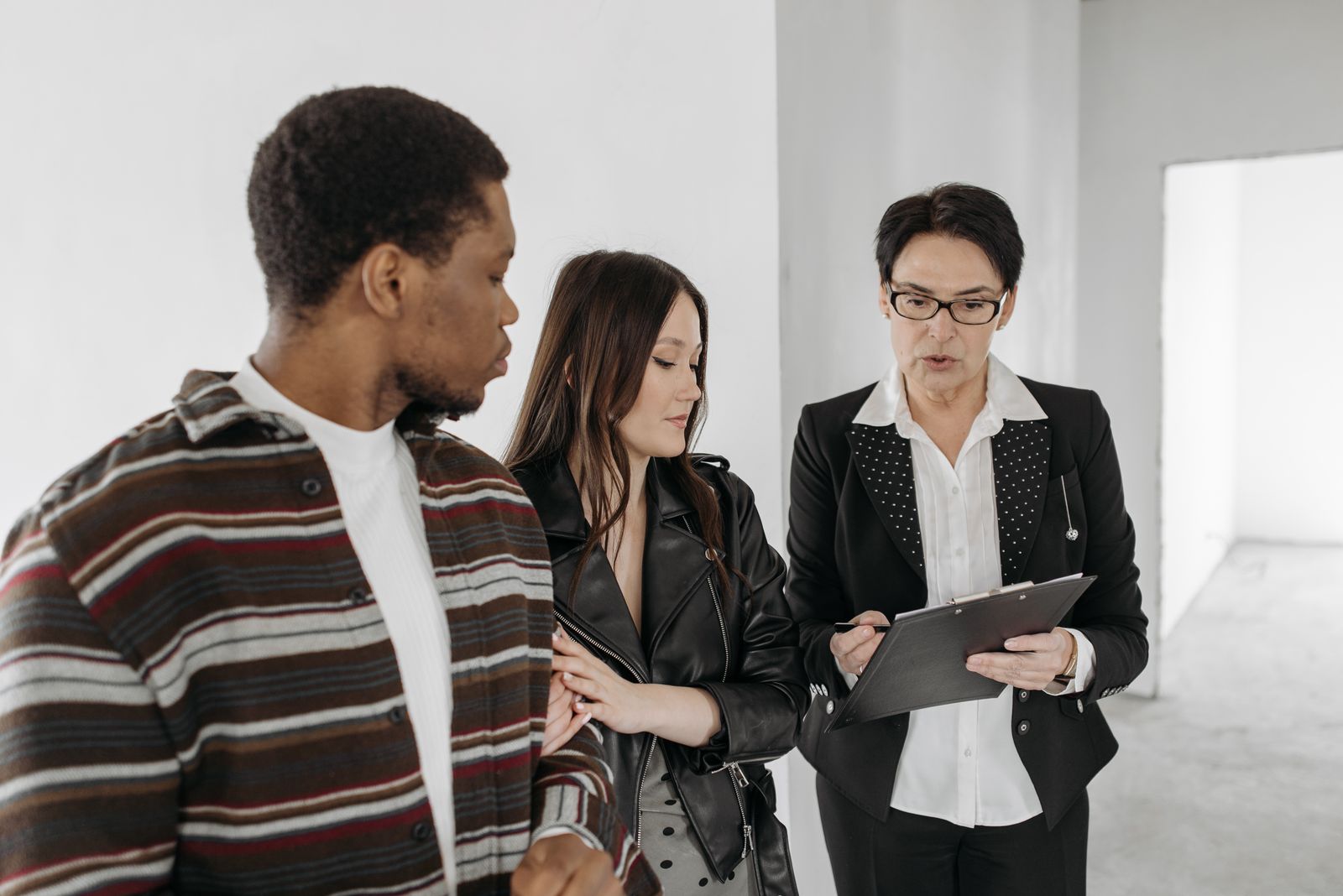 A realtor presenting new home details to a couple inside a spacious room
