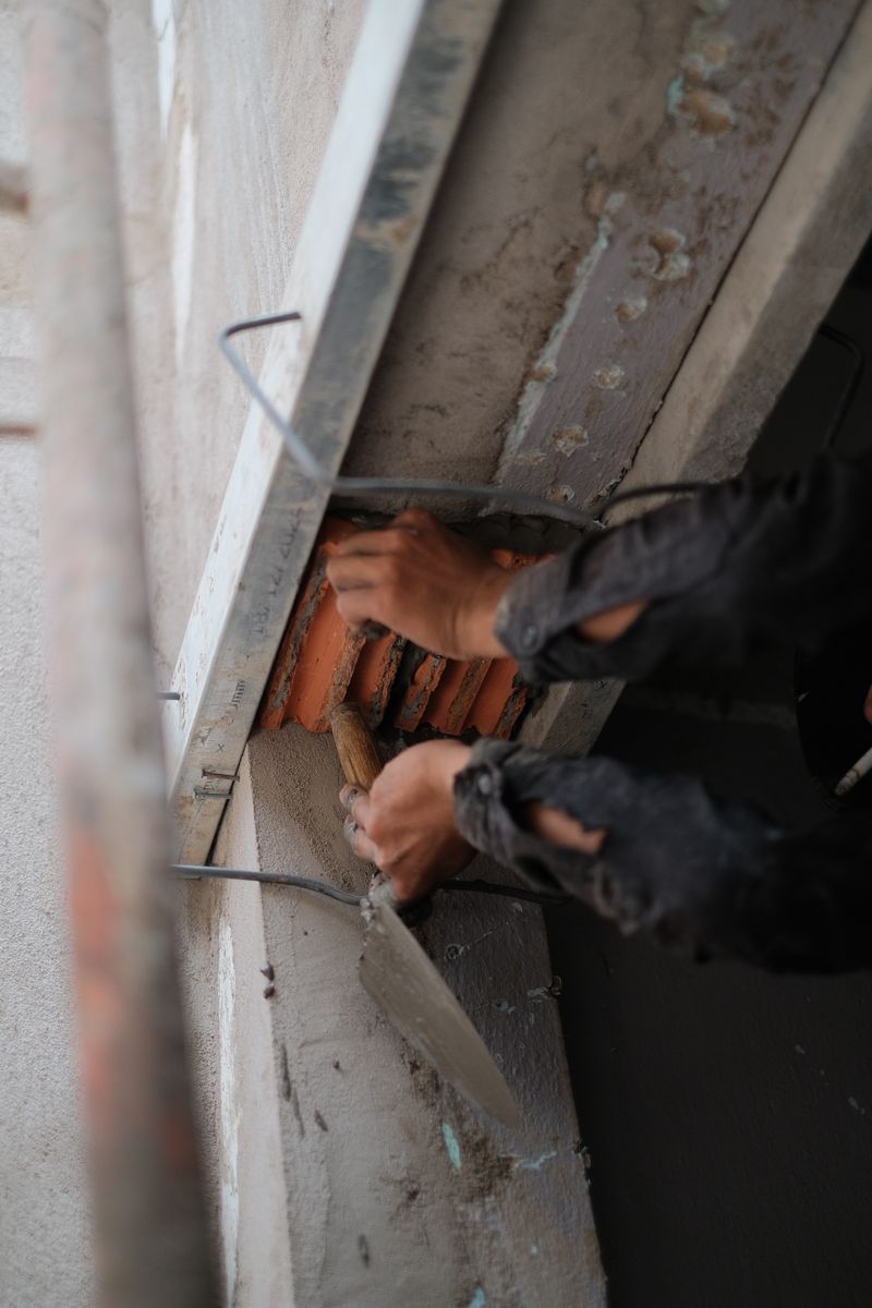 A worker repairing a wall surface with a trowel
