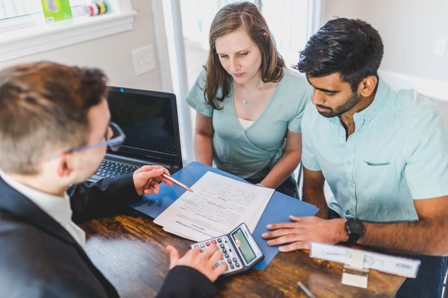 A couple meeting with their home loan advisor at a bright office desk