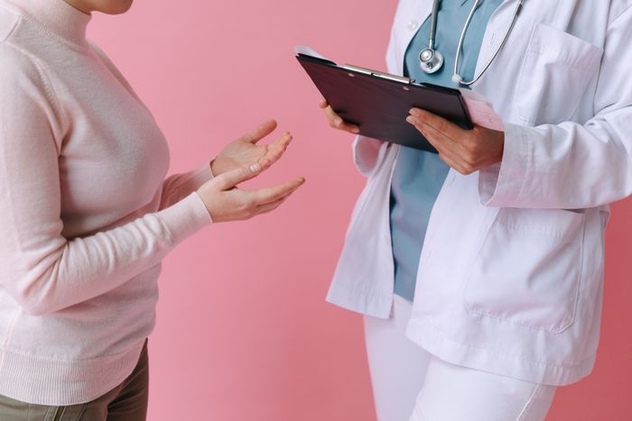Patient talking with a doctor holding a clipboard
