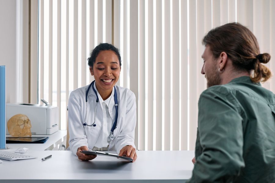 Smiling doctor talking through a patient's care plan on a clipboard