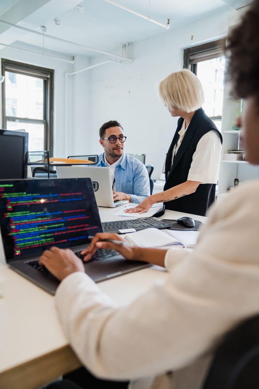 Diverse team collaborating on a programming project in a modern office setting