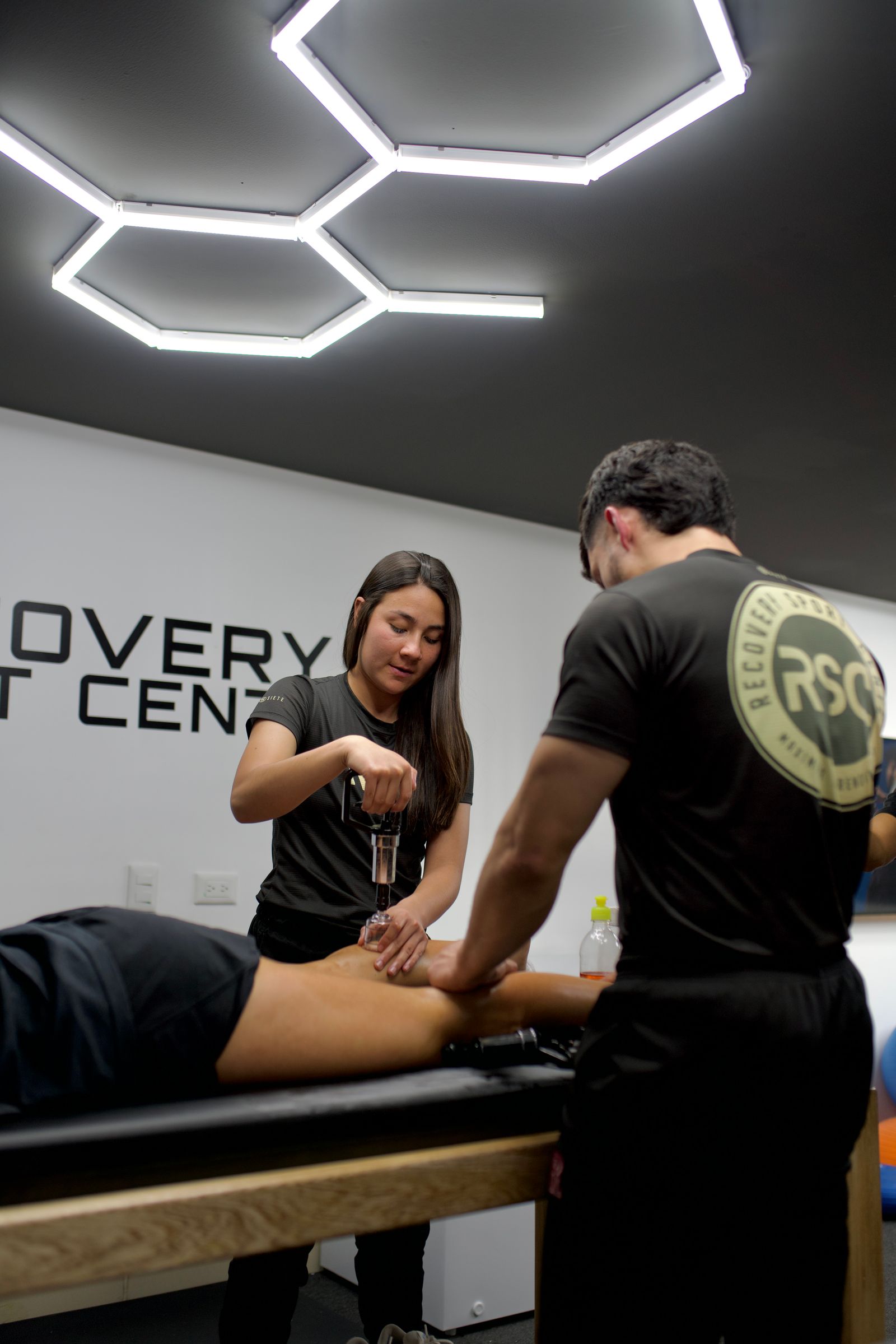 Two physiotherapists treating patients in a modern clinic fitted with specialised rehabilitation equipment