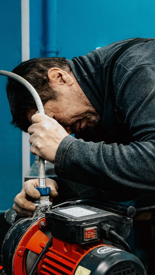 Tradesperson servicing a mechanical pump unit