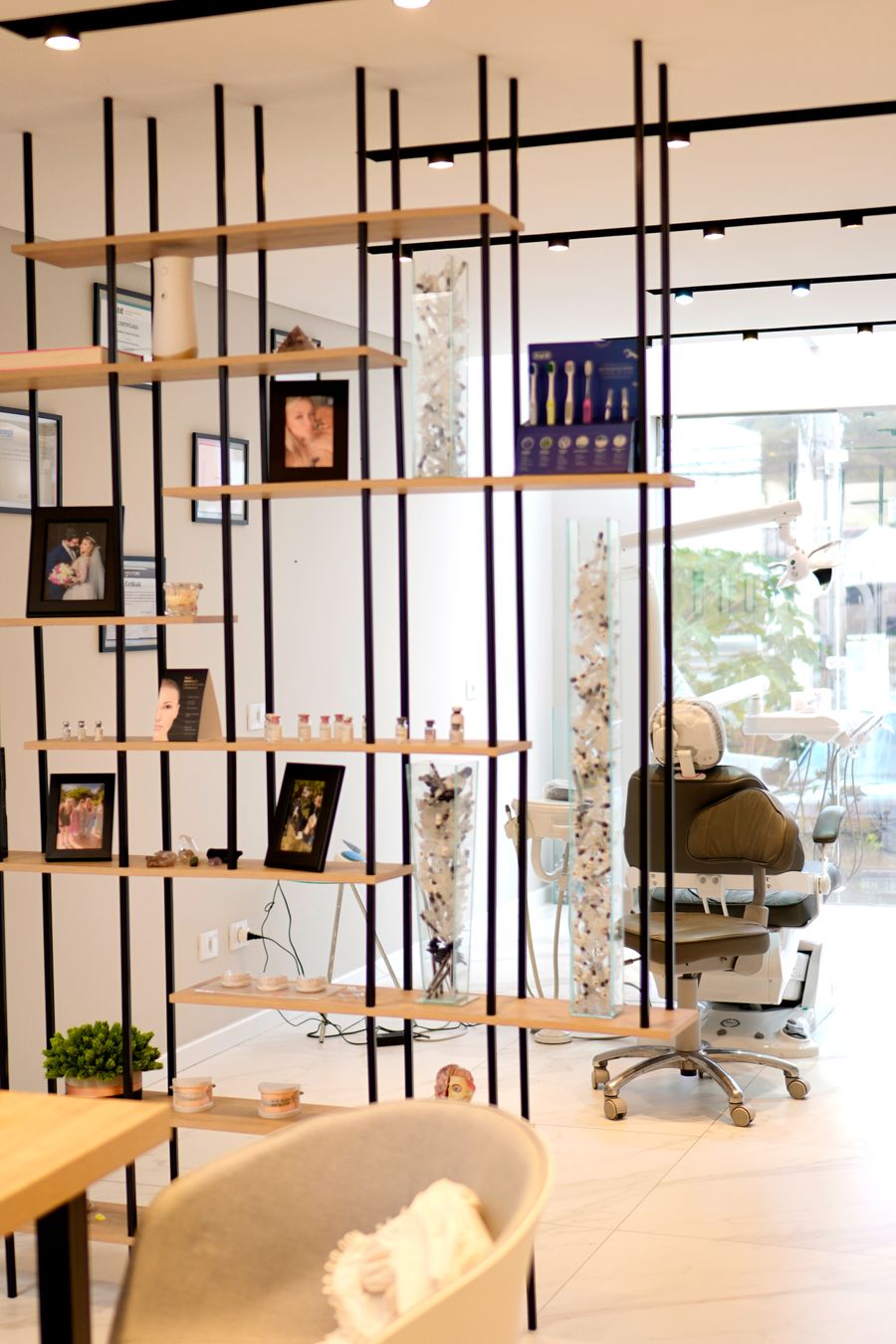 The practice interior: open shelving and a waiting chair, with a treatment chair beyond