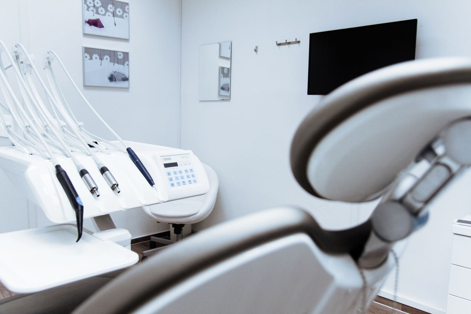 A treatment chair and instrument tray in a bright, uncluttered dental surgery