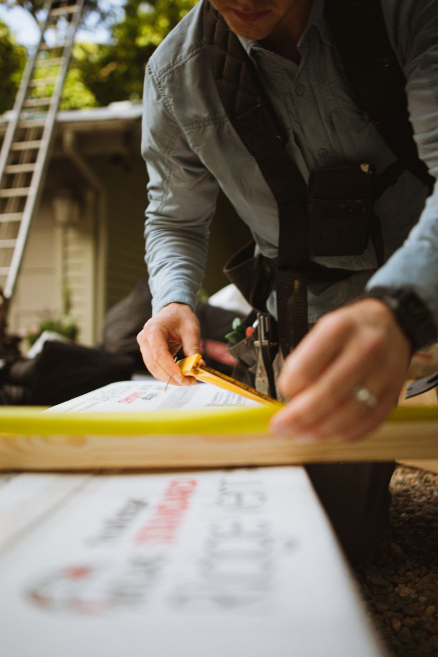 A tradesperson measuring materials outdoors during a home improvement job