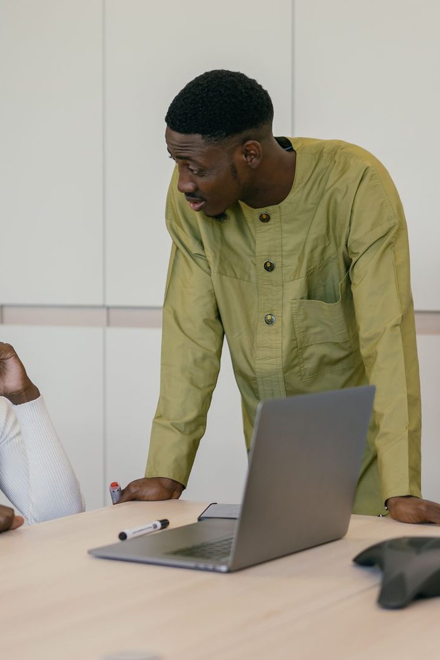Two IT consultants reviewing a project together at a laptop in a bright office